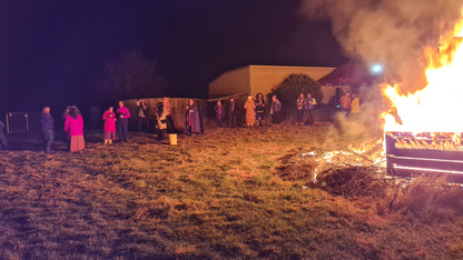 Revellers standing around a large burning fire.